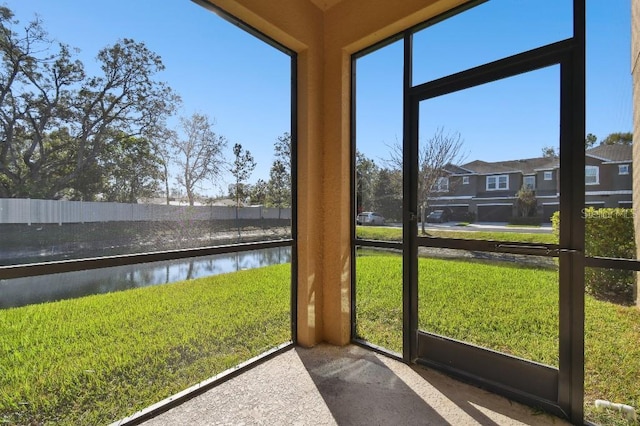 sunroom / solarium with a residential view and a water view