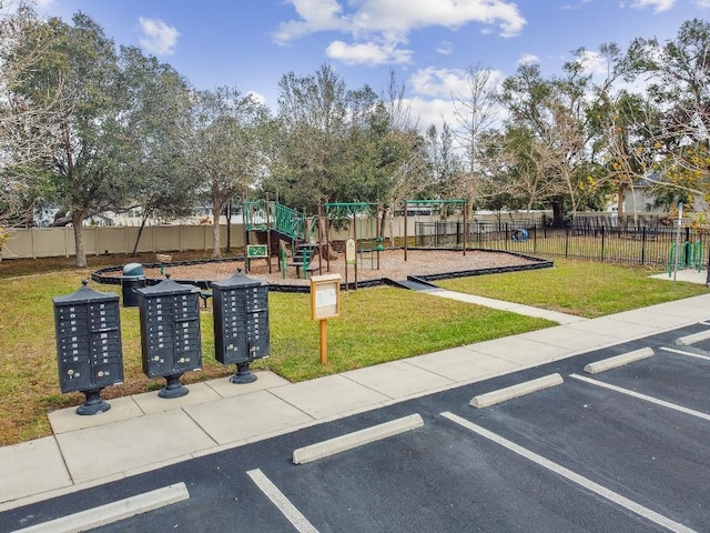 community play area featuring a yard and fence