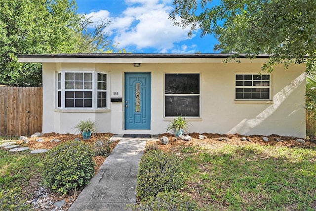 bungalow with stucco siding and fence