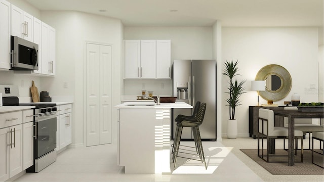 kitchen with a sink, light countertops, appliances with stainless steel finishes, white cabinets, and a kitchen island with sink