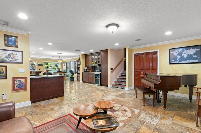 living area featuring beverage cooler, baseboards, stone tile flooring, stairs, and a dry bar