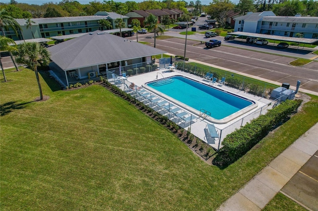 community pool with a residential view, a patio, a lawn, and fence