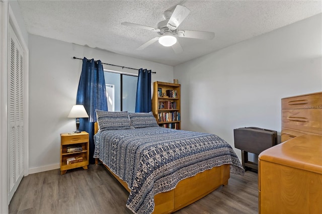 bedroom with baseboards, wood finished floors, a closet, a textured ceiling, and a ceiling fan