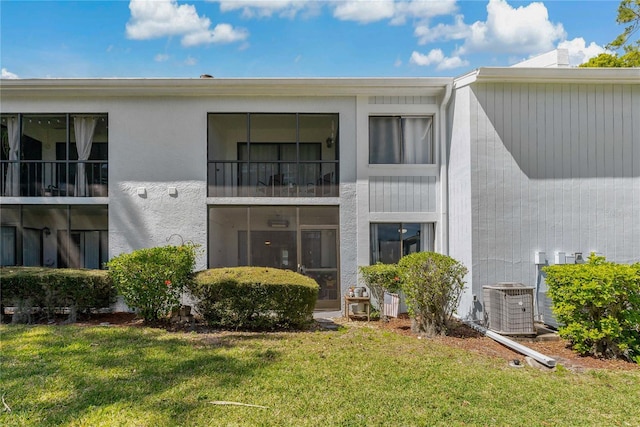 back of property with a lawn and cooling unit