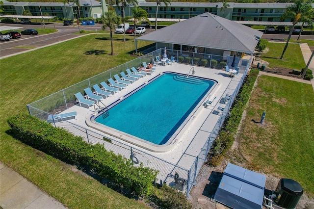 pool with a patio area, fence, and a lawn