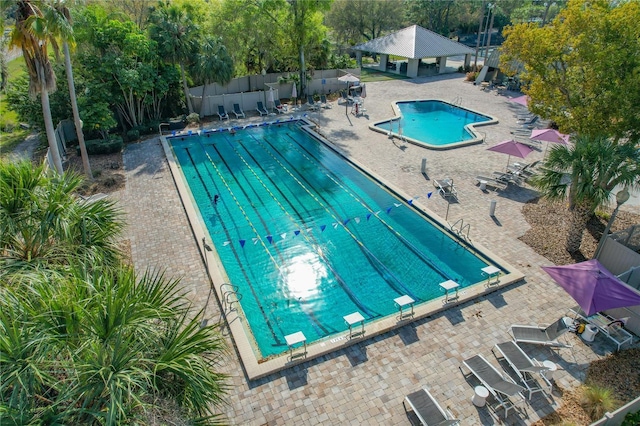 pool featuring a gazebo, a patio area, a diving board, and fence