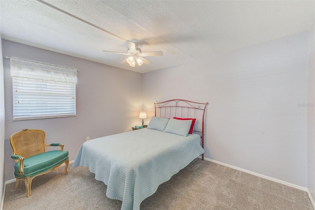 carpeted bedroom with a textured ceiling, baseboards, and a ceiling fan