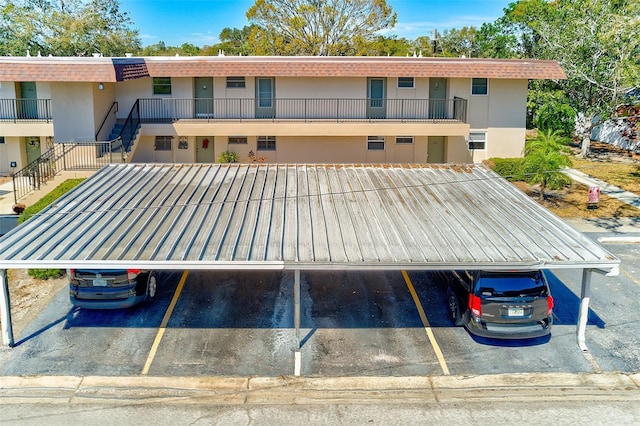 view of property featuring covered and uncovered parking