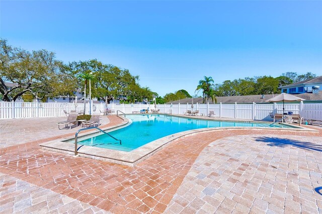 community pool featuring a patio area and fence