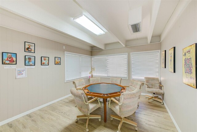 dining room featuring beam ceiling, baseboards, and wood finished floors