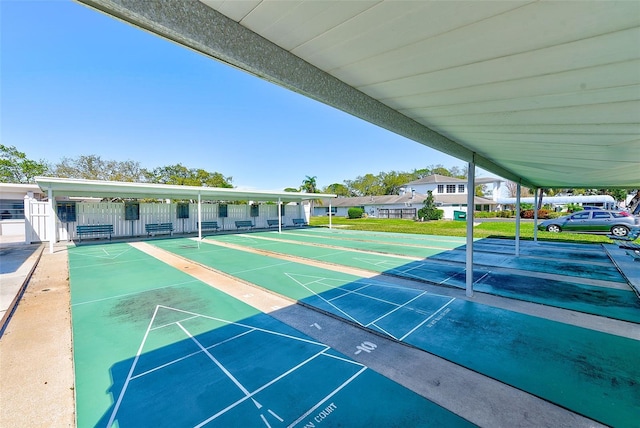 view of community with shuffleboard and fence