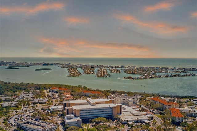 aerial view at dusk featuring a water view