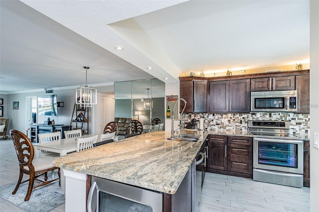 kitchen featuring backsplash, crown molding, dark brown cabinetry, light stone counters, and stainless steel appliances