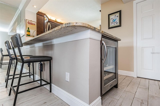 kitchen featuring a breakfast bar area, baseboards, and wood tiled floor