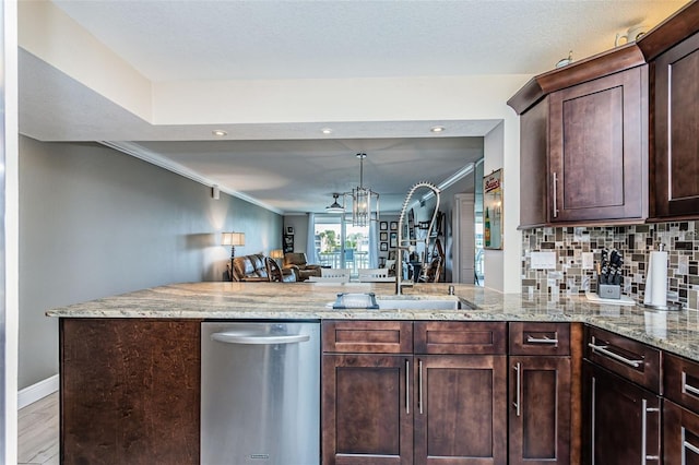 kitchen featuring light stone counters, open floor plan, dark brown cabinetry, a peninsula, and decorative backsplash