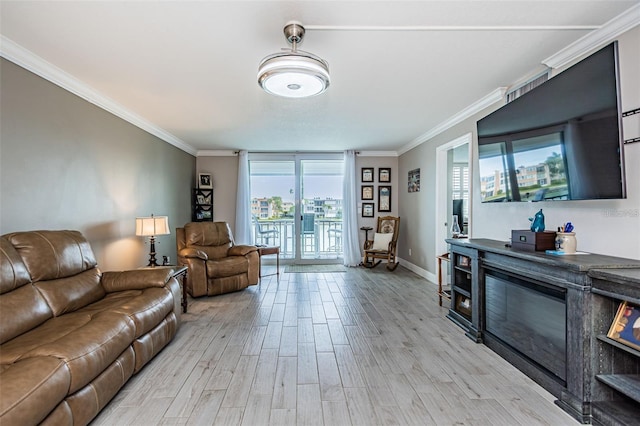 living area featuring crown molding, light wood-style flooring, and baseboards