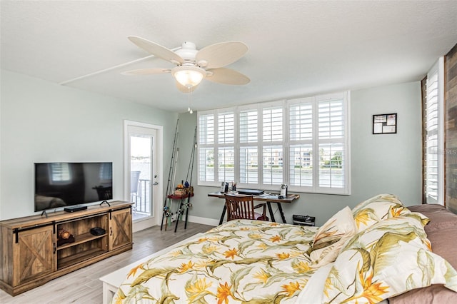 bedroom with a ceiling fan, baseboards, and wood finished floors