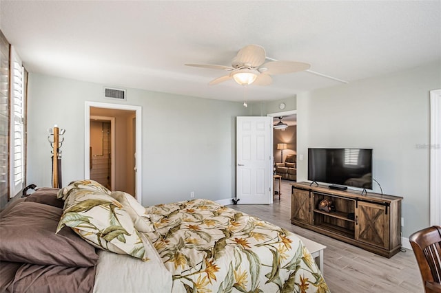 bedroom with visible vents, baseboards, a ceiling fan, and wood finished floors