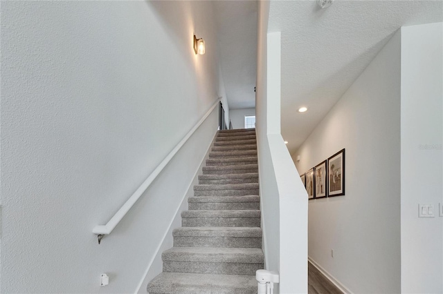 staircase with recessed lighting and a textured ceiling