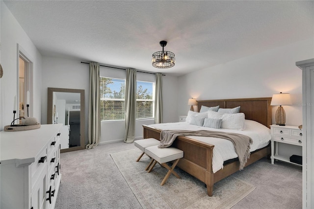 bedroom with light carpet, a textured ceiling, and a chandelier