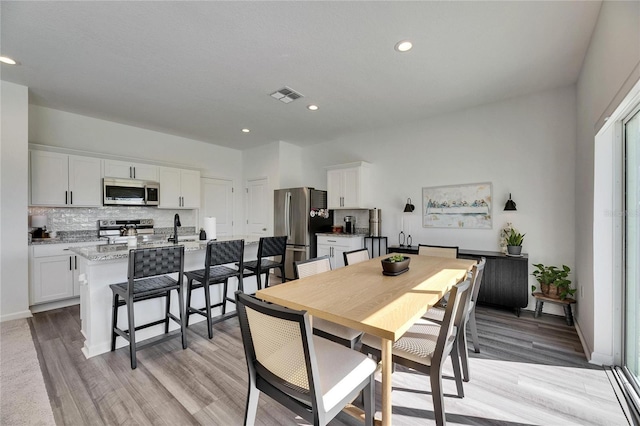 dining room featuring recessed lighting, visible vents, baseboards, and light wood finished floors