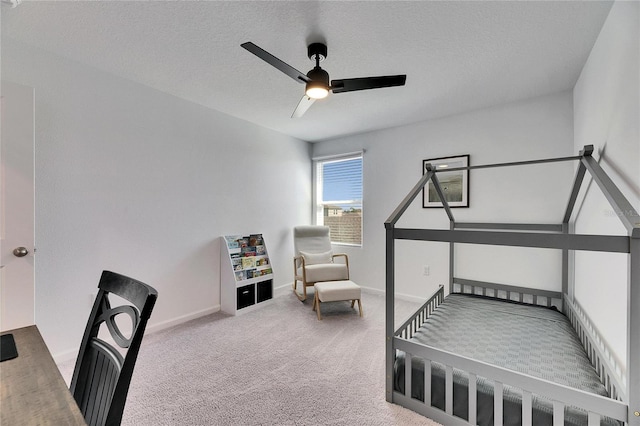 bedroom featuring a ceiling fan, baseboards, a textured ceiling, and carpet flooring