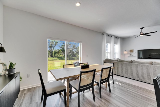 dining area featuring light wood-type flooring, baseboards, and ceiling fan