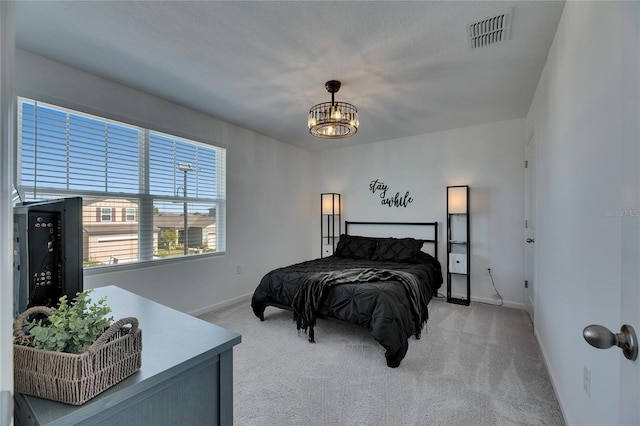 bedroom featuring an inviting chandelier, baseboards, visible vents, and light carpet