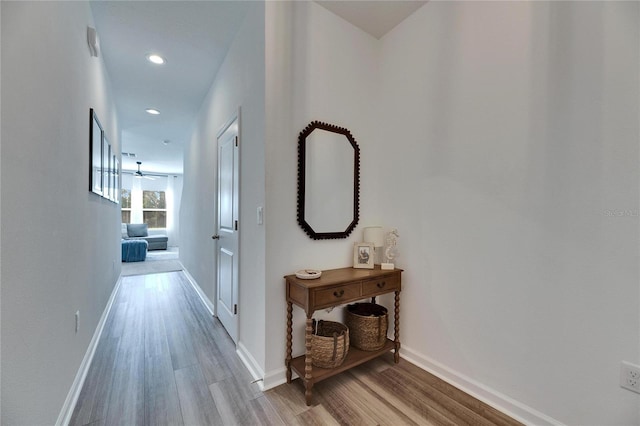corridor with recessed lighting, light wood-style floors, and baseboards