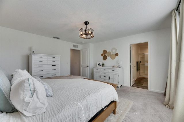 bedroom featuring light carpet, visible vents, ensuite bath, and baseboards