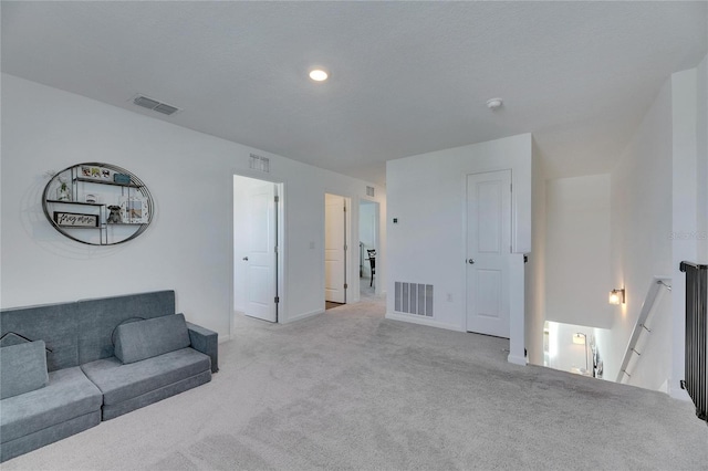 carpeted living area with baseboards and visible vents