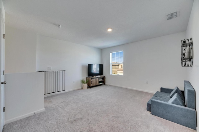 living area featuring visible vents, carpet floors, and baseboards