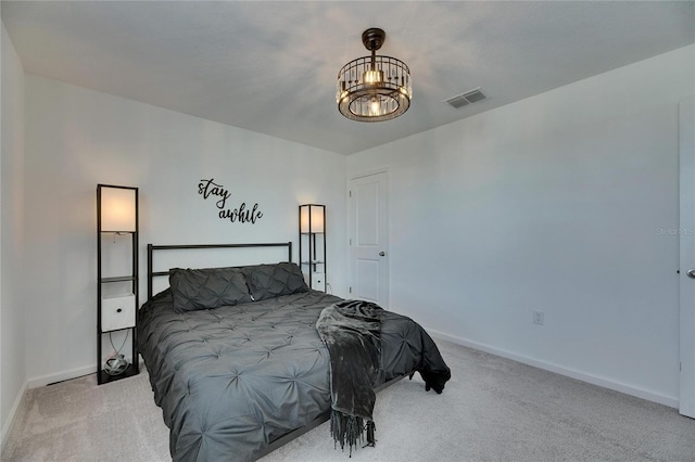 carpeted bedroom featuring visible vents, baseboards, and an inviting chandelier