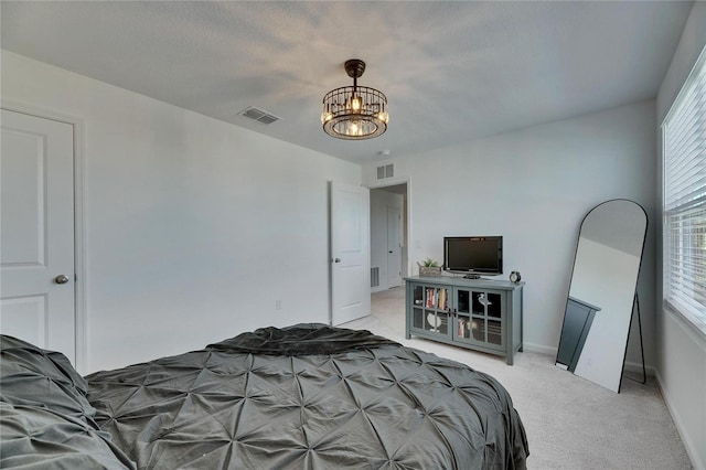 bedroom with visible vents, light carpet, a notable chandelier, and baseboards