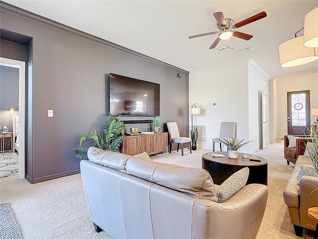 living room featuring a ceiling fan, light colored carpet, visible vents, and ornamental molding