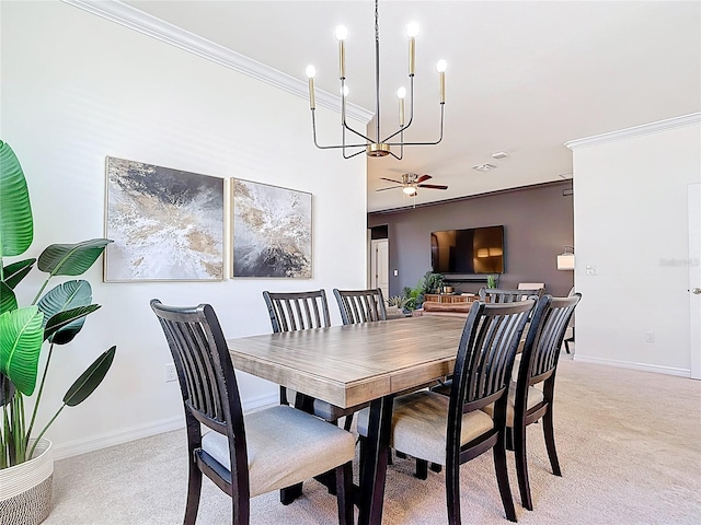 dining space with light colored carpet, ceiling fan with notable chandelier, baseboards, and ornamental molding