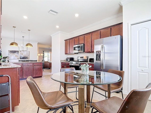 kitchen featuring crown molding, decorative light fixtures, visible vents, and stainless steel appliances