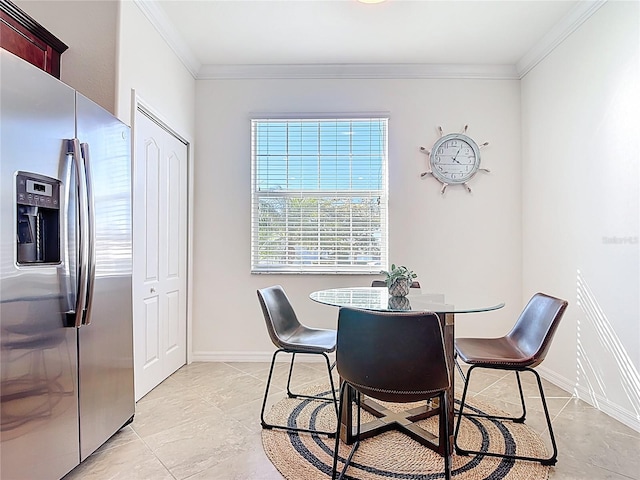 dining space featuring baseboards and crown molding