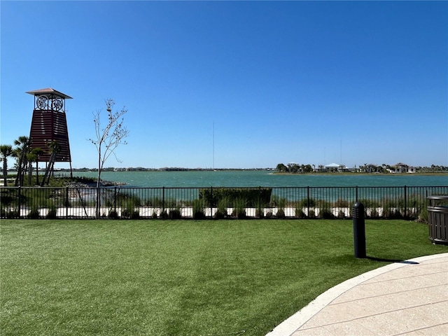 view of home's community with a water view, fence, and a yard