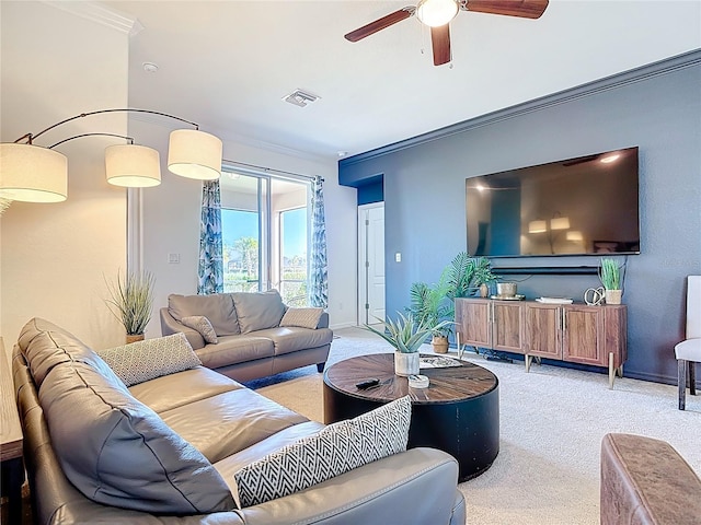 carpeted living area featuring a ceiling fan, crown molding, baseboards, and visible vents
