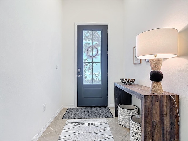 foyer featuring light tile patterned flooring and baseboards