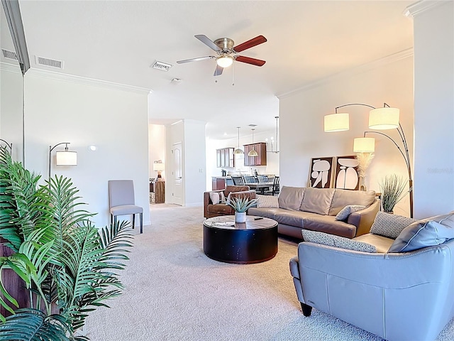 living room with a ceiling fan, ornamental molding, light colored carpet, and visible vents