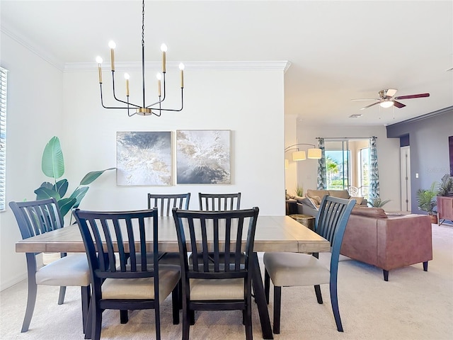 dining area with ceiling fan with notable chandelier, light carpet, crown molding, and baseboards