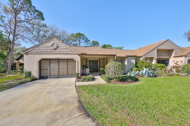 single story home with stucco siding, driveway, a garage, and a front yard