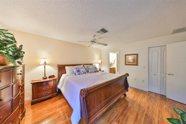 bedroom with light wood finished floors, visible vents, baseboards, ceiling fan, and a closet