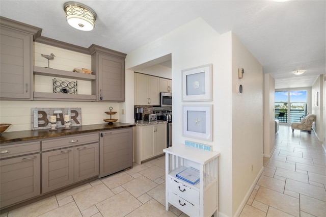 kitchen with gray cabinetry, open shelves, stainless steel appliances, decorative backsplash, and baseboards