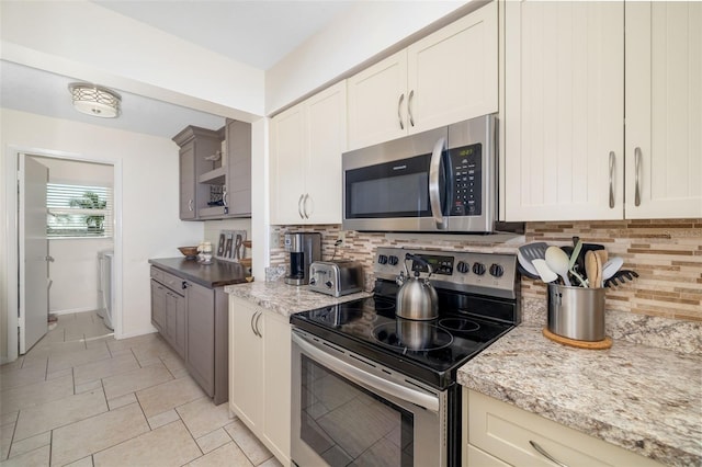 kitchen featuring washer / clothes dryer, baseboards, tasteful backsplash, and appliances with stainless steel finishes