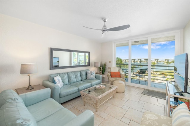 living room featuring expansive windows, light tile patterned floors, and ceiling fan