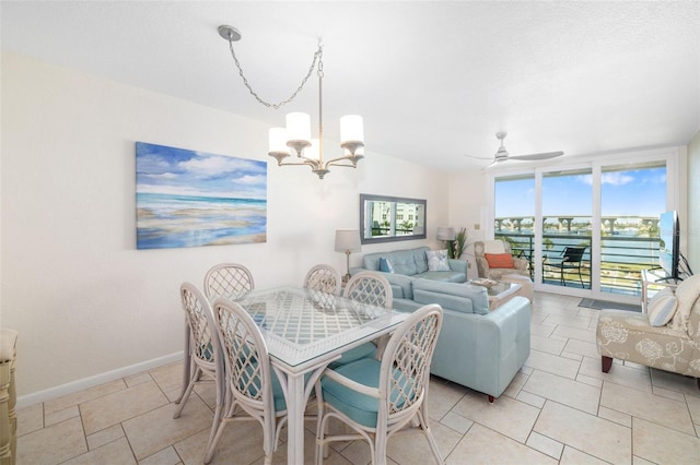 dining area featuring plenty of natural light, ceiling fan with notable chandelier, and baseboards