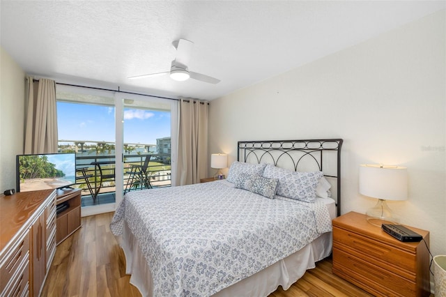 bedroom with floor to ceiling windows, access to outside, wood finished floors, and ceiling fan